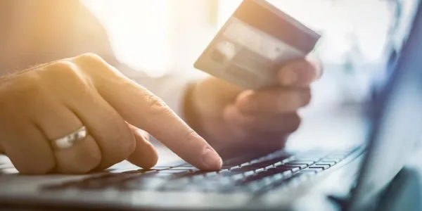 Dłoń z kartą kredytową przy laptopie – zakupy online i sklepy internetowe w Chicago